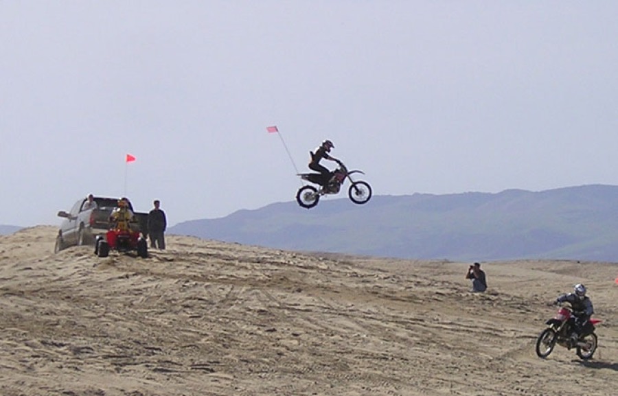 Dirt bike jumping off a dune