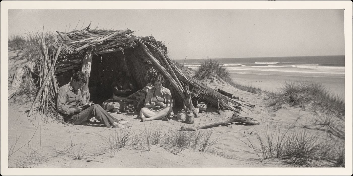 AI recreation styled after 1930s photographs of Dunites colony members outside a driftwood and reed cabin in the dunes