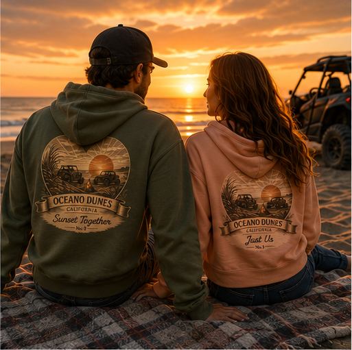 A couple in military green and peach CCWheelers Sunset Collection crop hoodies watching the sun set over the water, Oceano Dunes California