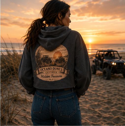 A rider in a charcoal CCWheelers Sunset Collection crop hoodie standing in the dune grass at sunset, Oceano Dunes California