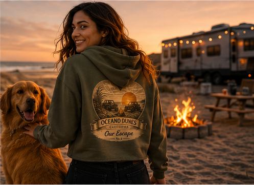 A rider in a military green Sunset Collection crop hoodie with a golden retriever beside a trailer and campfire at dusk, Oceano Dunes California