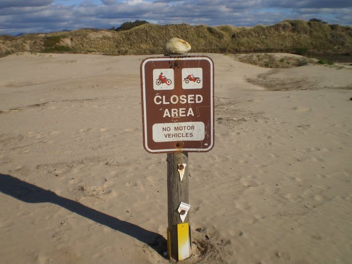 Closed area no motor vehicles sign posted in a restricted dune area at Oceano Dunes