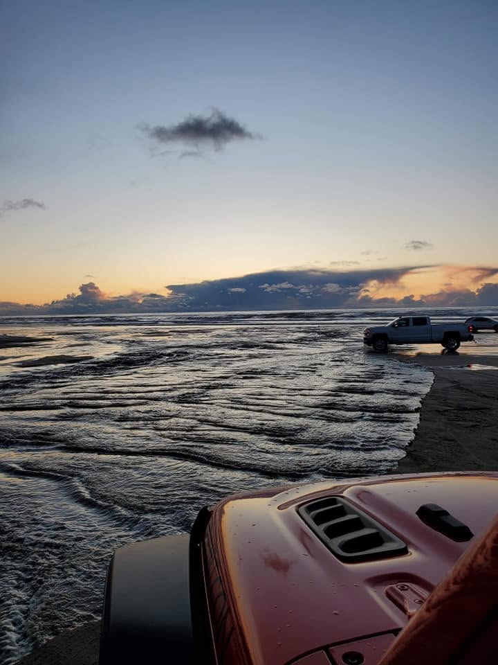 Trucks parked at the Arroyo Grande Creek crossing at sunset at Oceano Dunes, California