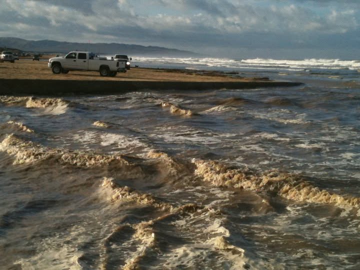 Rushing whitewater where Arroyo Grande Creek meets the ocean surf at Oceano Dunes